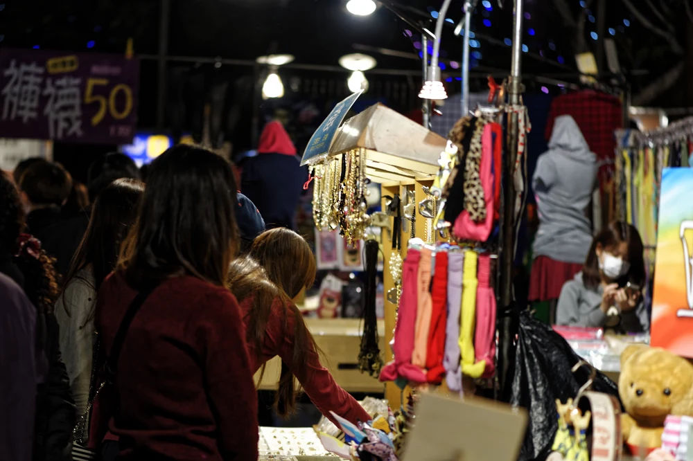 People walking along stalls at a night market