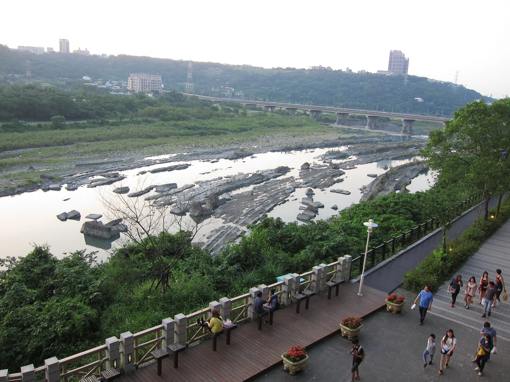 People walking on a bridge by the river